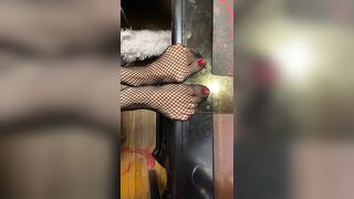 red nail polish tiny feet in fishnet stocking